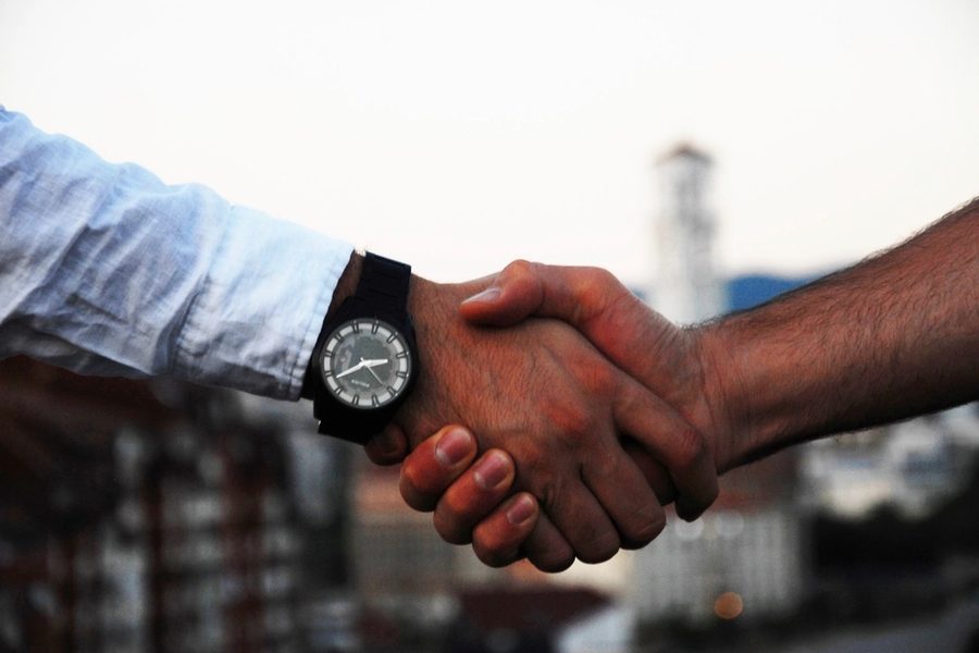 A handshake with a city skyline behind